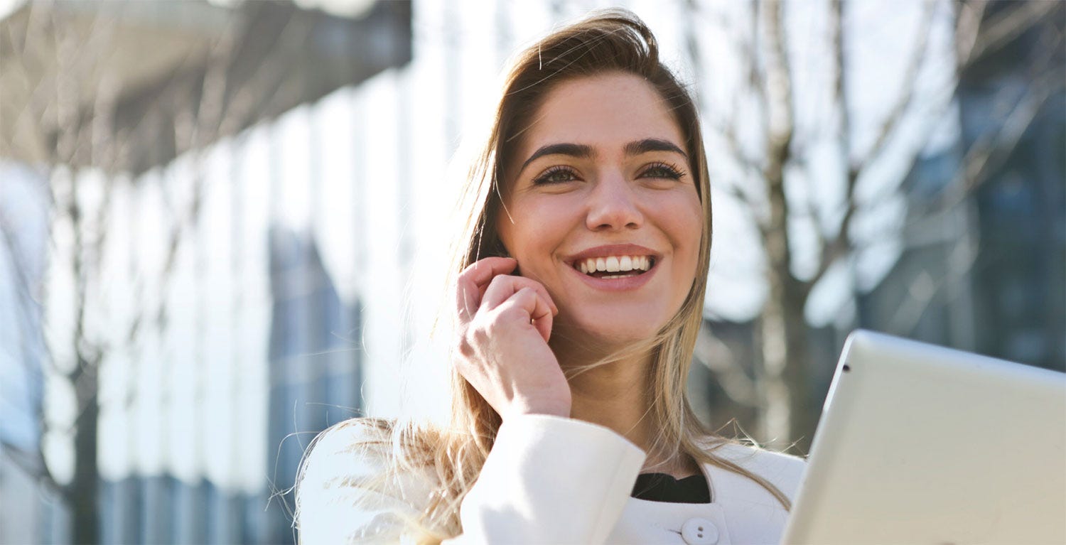 Smiling woman on phone with table in her hand