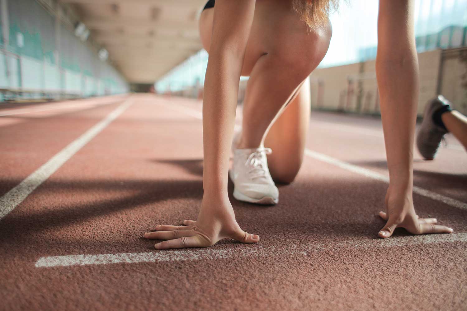 Closeup of woman kneeling down by starting line