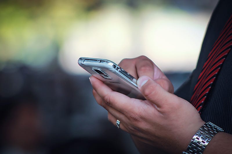 Man with silver coloured phone in hands